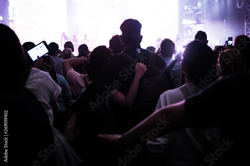 people at a concert with their hands in the air dancing and singing 