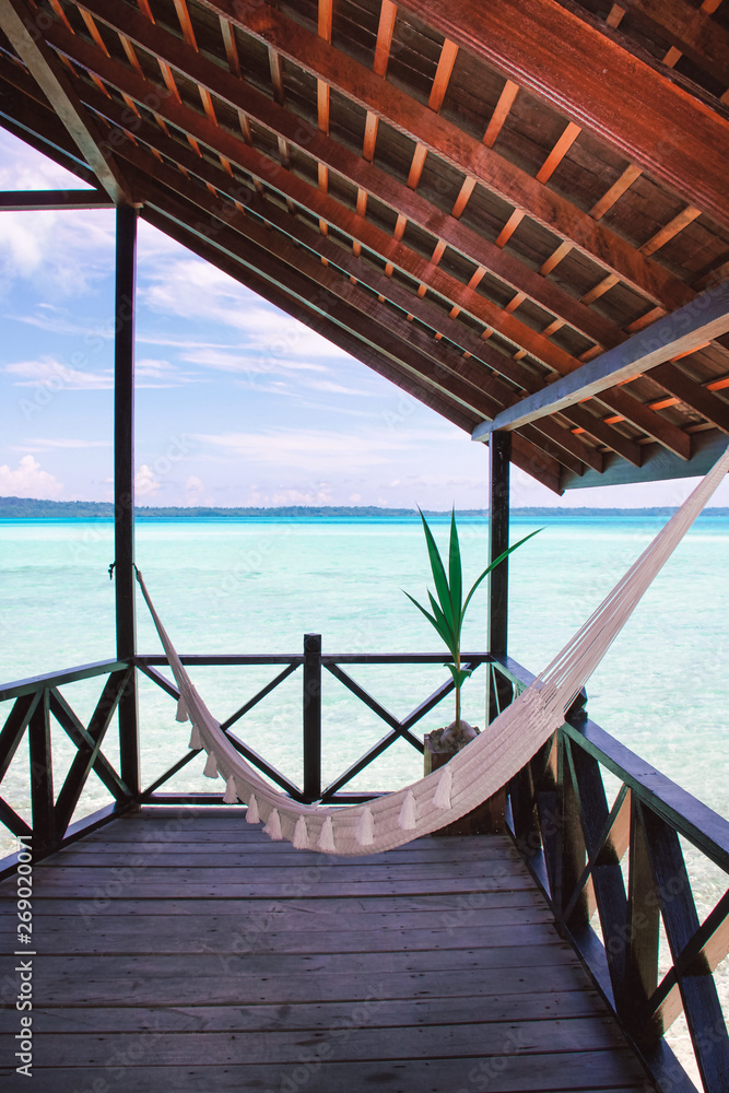 cotton white hammock on a wooden veranda on a tropical sea