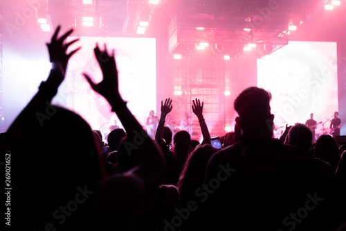 people at a concert with their hands in the air dancing and singing 