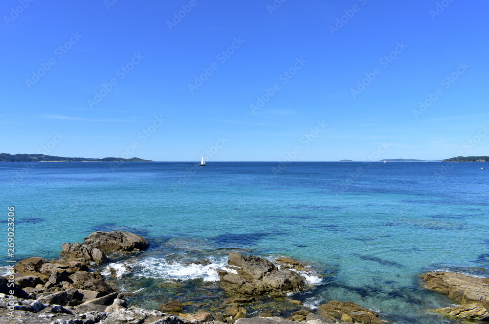 Bay with rocks, sailing boats and blue sky. Rias Baixas, Spain. Bay with rocks, sailing boats and blue sky. Rias Baixas, Spain.