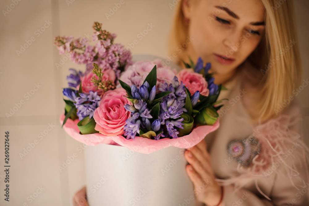 Attractive girl with bouquet in hat box