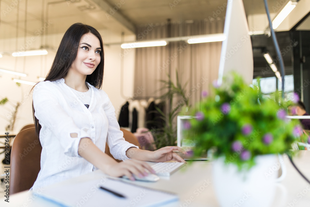 Side view portrait of businesswoman using computer at office desk