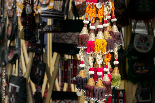 Traditional Asian women's jewelry with embroidered colored thread and silver coins in a street market store © alexey_arz
