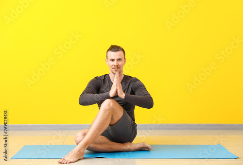 Sporty man practicing yoga ...