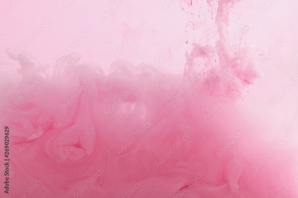 Close up view of pink paint mixing in water