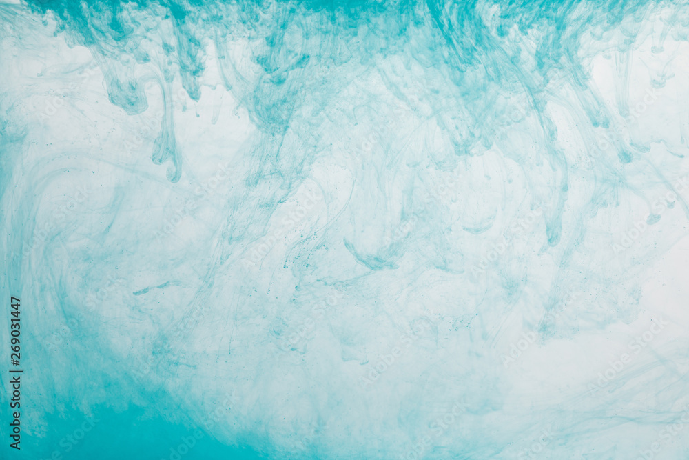 Fototapeta premium Close up view of light blue paint swirls in water