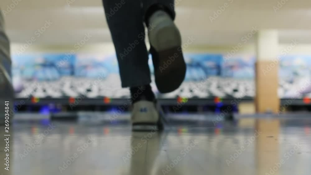Closeup bottom view of skullful excited young man throwing bowling