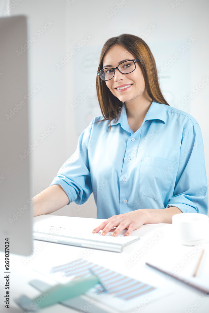 Portrait of a smiling business woman working at the computer in the office. Portrait of a smiling business woman working at the computer in the office.