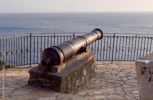 Old metal cannon against the sea