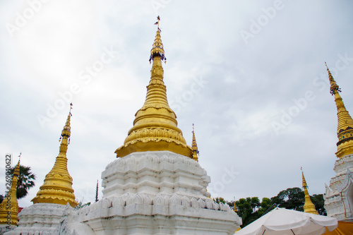 Many golden pagodas on the courtyard of temple in northern thailand  with blue sky background.