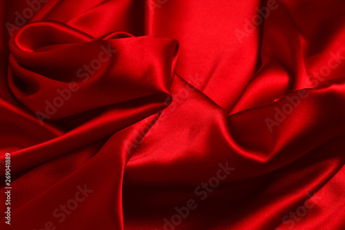 Red silk or satin luxury fabric texture can use as abstract background. Top view.