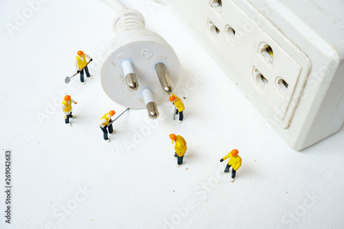 miniature electronic technician working to connect electricity photo