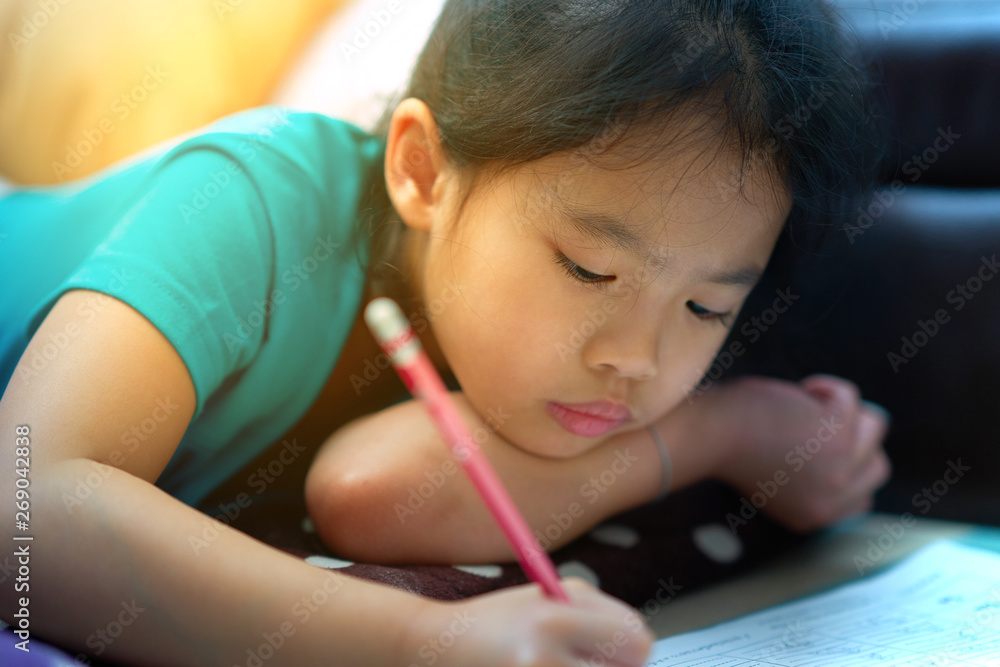 Girl lies down for writing notebook on floor Girl lies down for writing notebook on floor