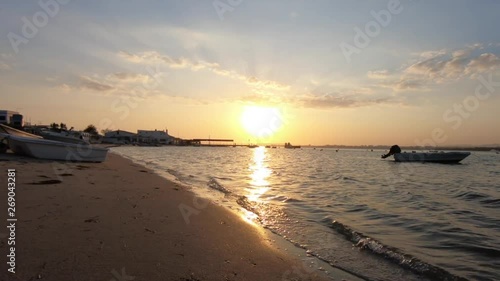Fixed shot of a Sunset in the shore of the Ria Formosa among the fishing boats. Armona Island, Algarve. Portugal.