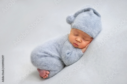 Sleeping newborn boy in the first days of life on white background
