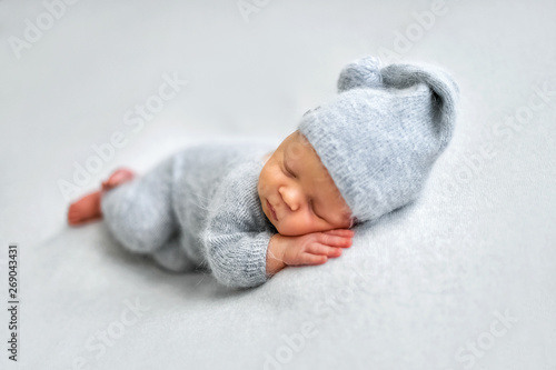 Sleeping newborn boy in the first days of life on white background