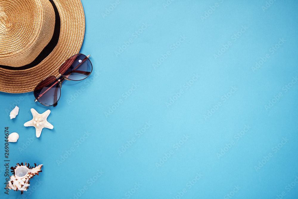 hat smartphone and sunglasses blue background - obrazy, fototapety, plakaty 