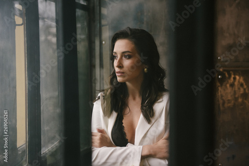 Young brunette woman posing in a suit by the window © Alexander