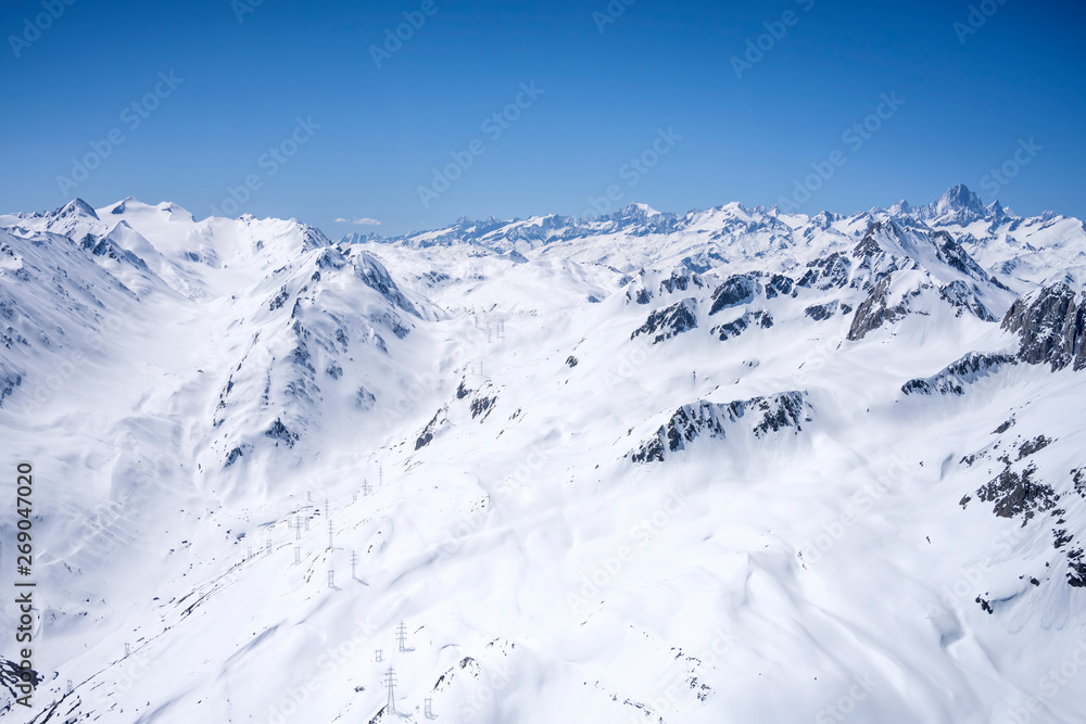 Obraz premium power lines crossing san Giacomo pass covered with sping snow, Ticino, Switzerland
