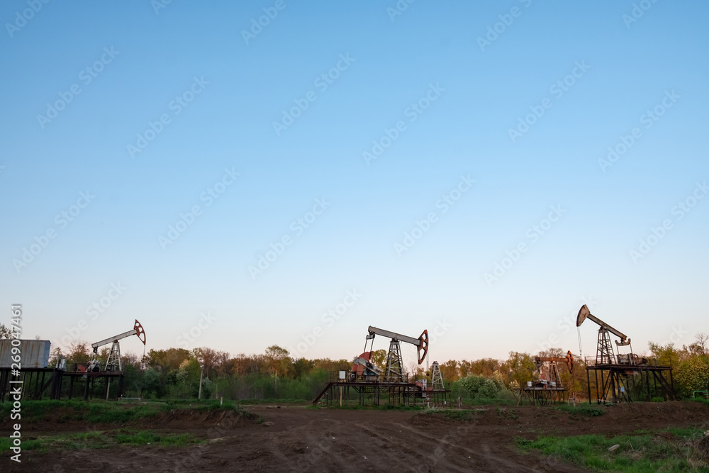 Fototapeta premium Oil and gas production equipment running at sunset