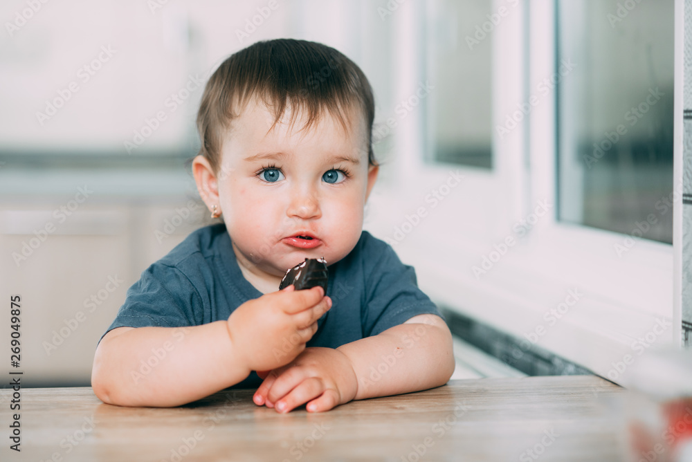 Little girl in the kitchen eating marshmallows in chocolate or chocolate chip cookies Little girl in the kitchen eating marshmallows in chocolate or chocolate chip cookies