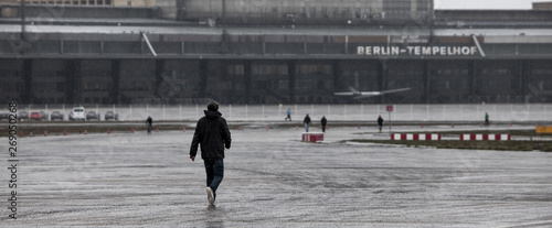 a young man walking toward the tempelhof airfield building berlin germany photo