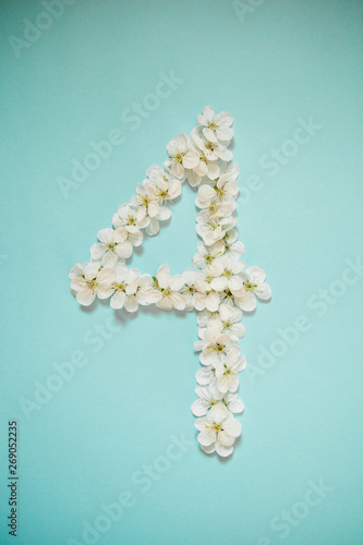 White flowers in the form of numbers on a blue sky background. Photo for design with place for text.
