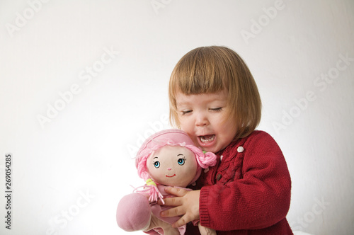 little girl smiling happy. cute caucasian baby with bear and doll isolated on white background