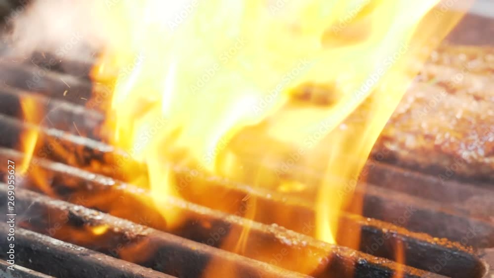 Chief cooked meat for a burger on the grill turning using the spatula ...