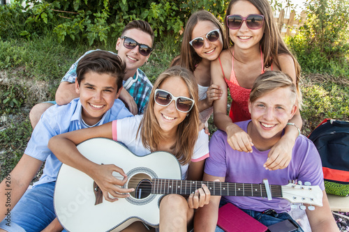 group of teenagers spending time together with guitar #269056626