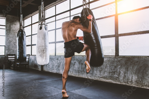 Muay thai fighter training in gym with punching bag