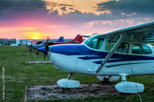 Cuadro en lienzo Small private aircrafts parked at the airfield at picturesque sunset