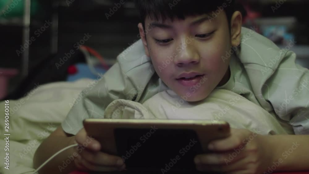 Young asian happy boy to using on the tablet with smile face. Young asian happy boy to using on the tablet with smile face.