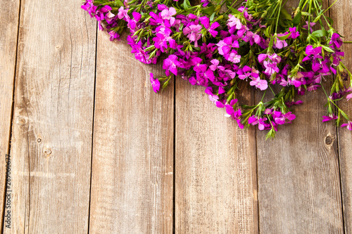 Purple flowers on wooden background