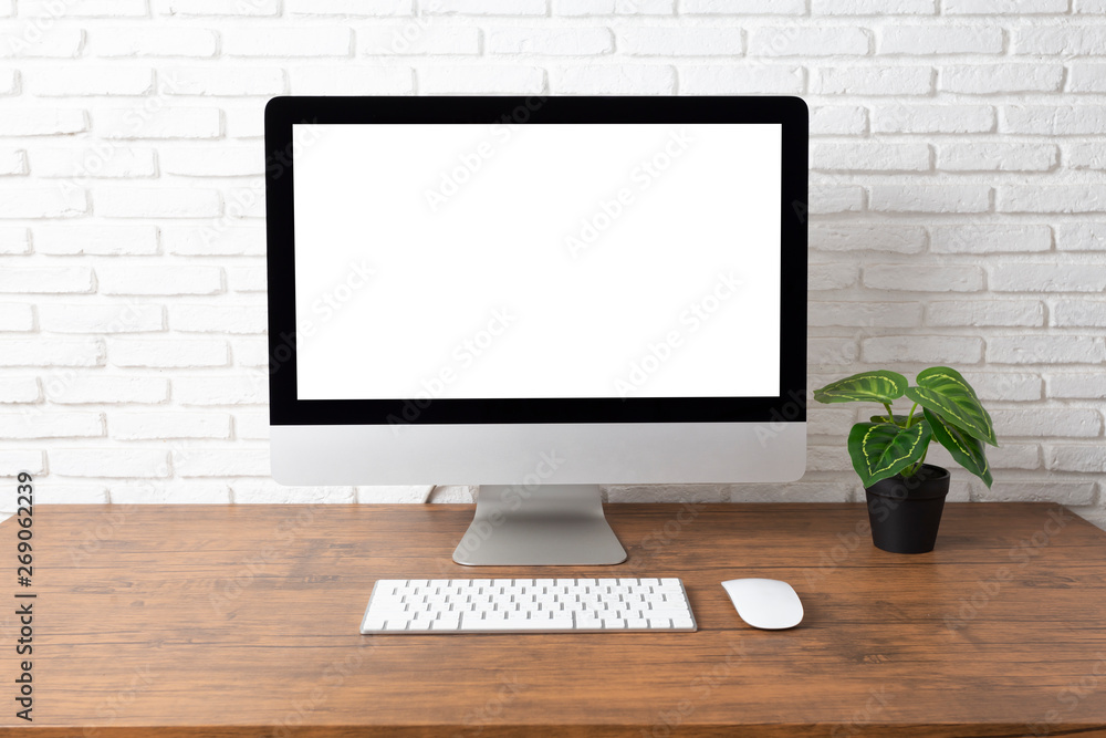 Fototapeta premium workspace with computer with blank white screen, and office supplies on a wooden desk