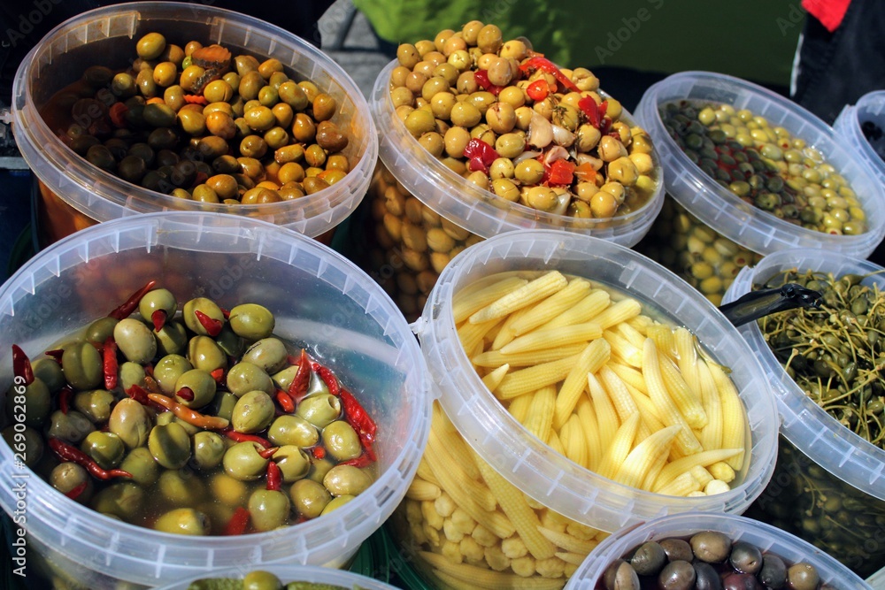 Buckets full of olives , pickles and baby corn