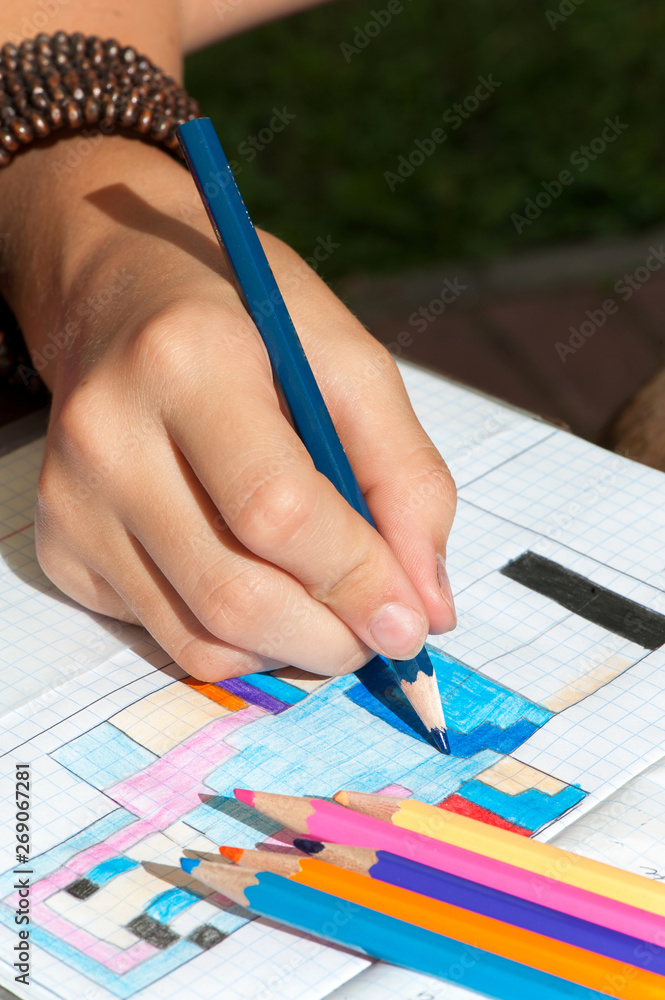 Naklejka premium Child hand draws the multicolored picture.