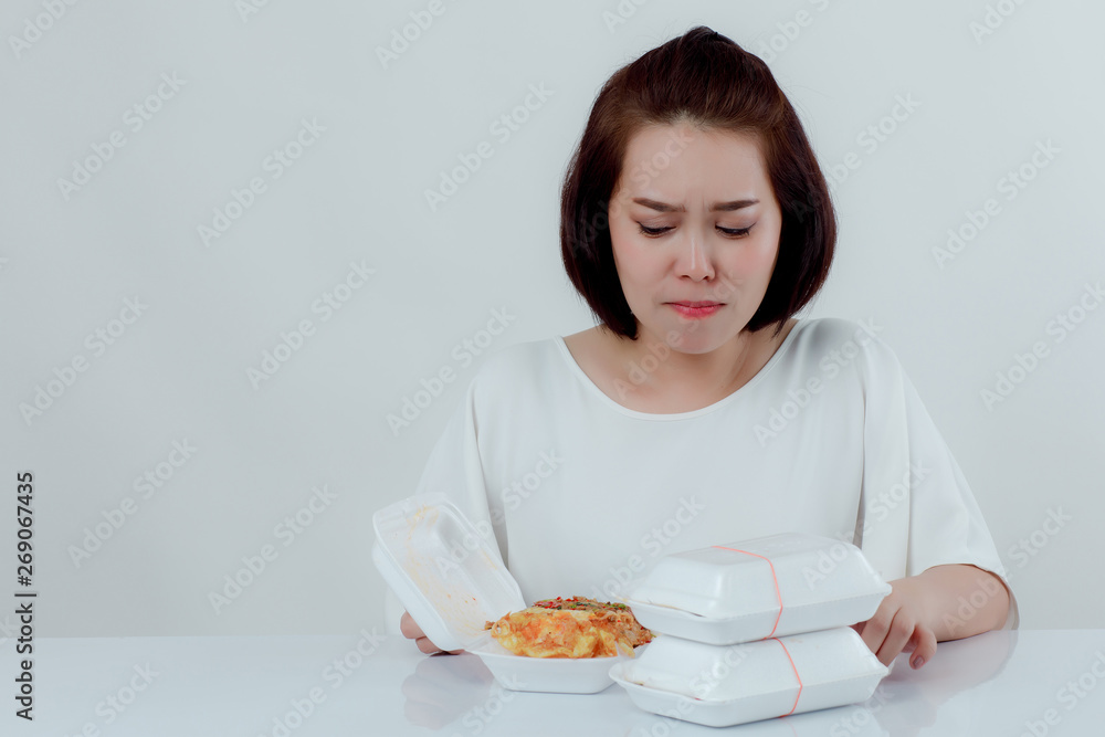 Beautiful Asian woman, white shirt Sitting in front of the dining table There is an expression of disgust in the foam box. Do not support using food foam Placed in front With a white background Beautiful Asian woman, white shirt Sitting in front of the dining table There is an expression of disgust in the foam box. Do not support using food foam Placed in front With a white background