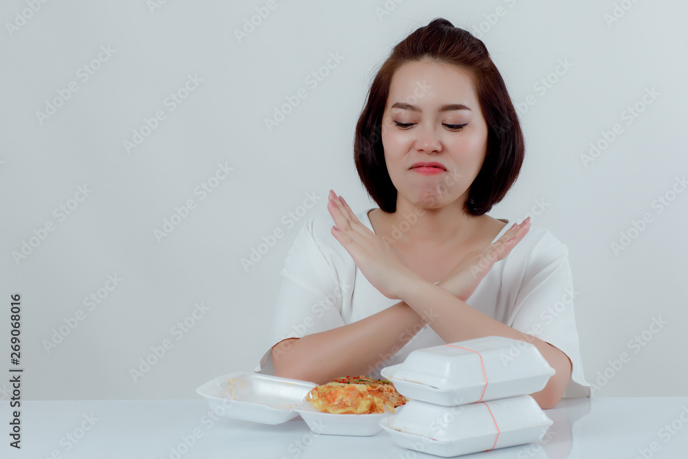 Beautiful Asian woman, white shirt Sitting in front of the dining table There is an expression of disgust in the foam box. Do not support using food foam Placed in front With a white background Beautiful Asian woman, white shirt Sitting in front of the dining table There is an expression of disgust in the foam box. Do not support using food foam Placed in front With a white background