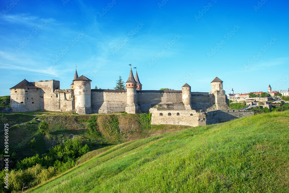 Summer landscape with green fields, antique fortress Kamianets-Podilskyi in Ukraine