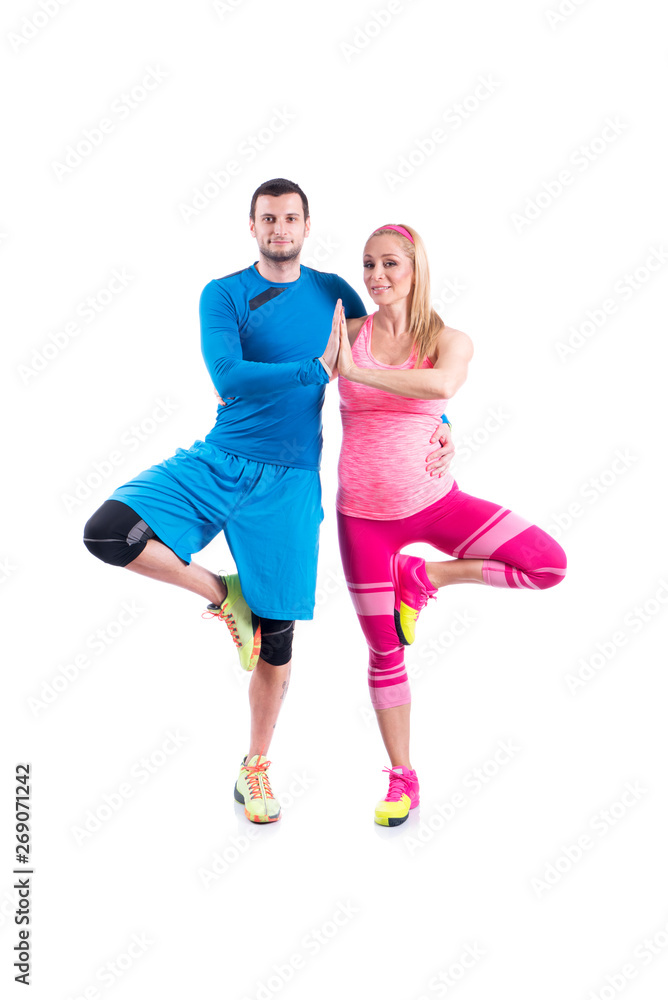 Happy young couple doing exercise in pair for pregnancy on the white background.