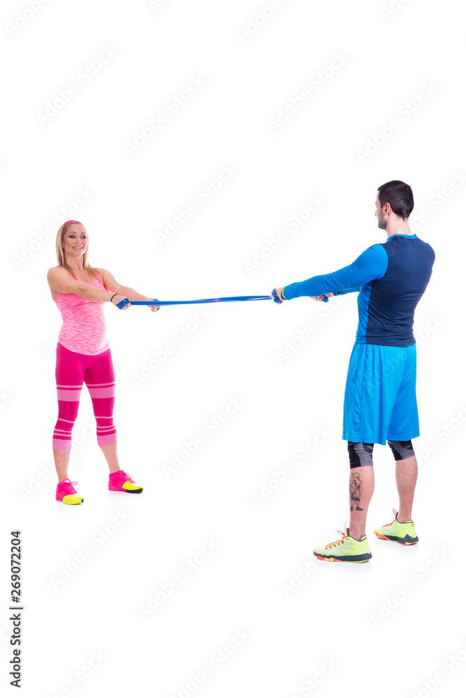 Happy young couple doing exercise in pair with elastic rubber for pregnancy on the white background. Happy young couple doing exercise in pair with elastic rubber for pregnancy on the white background.