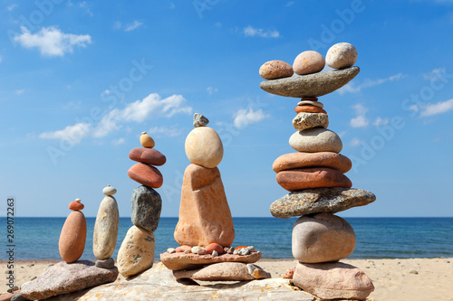 Photography Several Rock zen pyramids of colorful pebbles on a beach on the background of the sea