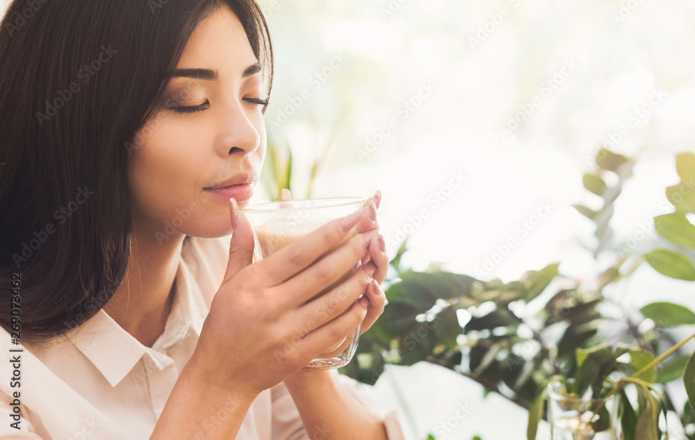 Attractive asian woman enjoying the smell of morning coffee Attractive asian woman enjoying the smell of morning coffee
