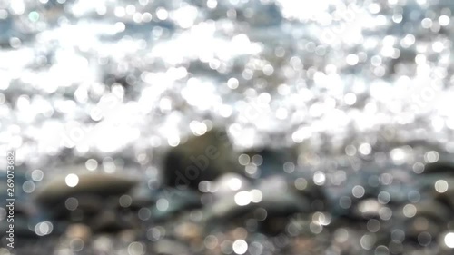Defocused blur sea water background with sun sparkles and glitter