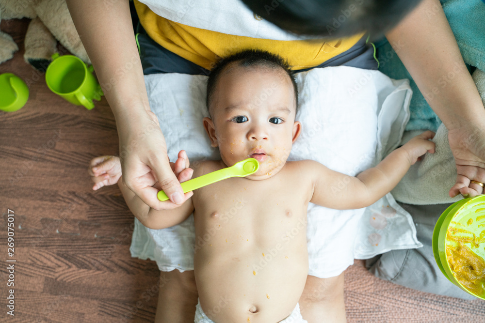 Toddler child boy try to eat pap food by hand of mom Toddler child boy try to eat pap food by hand of mom