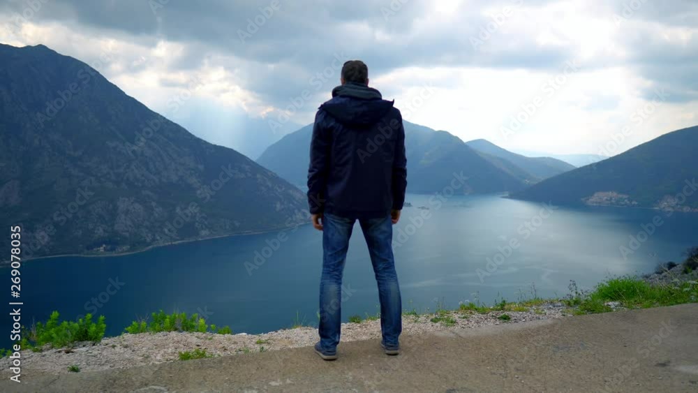 back view tourist in mediterranean city. man standing looking on amazing nature view in chilly overcast day back view tourist in mediterranean city. man standing looking on amazing nature view in chilly overcast day