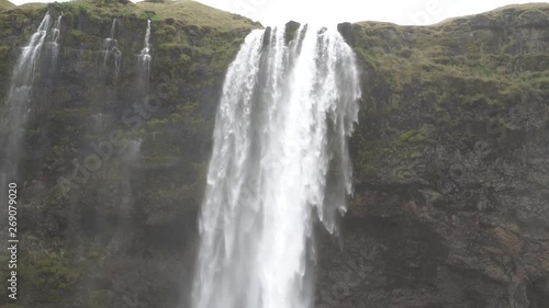 Beautiful Iceland Waterfall with cloudy skies and rocks and grass
