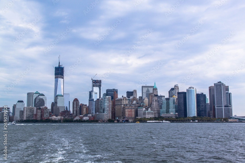 Fototapeta premium Wspaniały widok na panoramę Manhattanu. Wysokie budynki na błękitnym niebie z białymi chmurami w tle. Piękne tła. Nowy Jork. USA