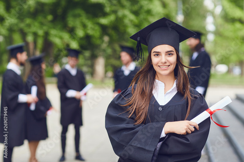 Photos A young female graduate against the background of university graduates